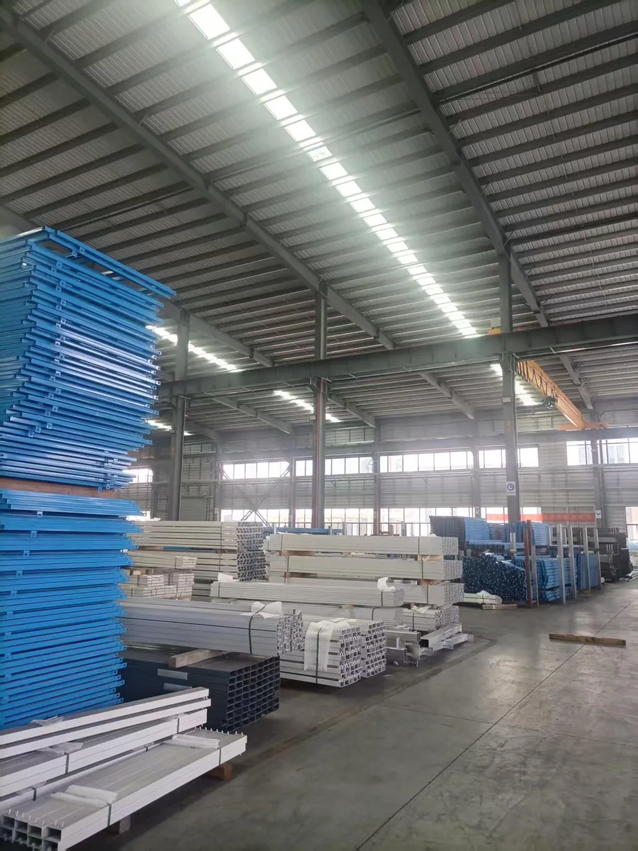 Stacks of blue steel frames and white steel profiles inside the factory
