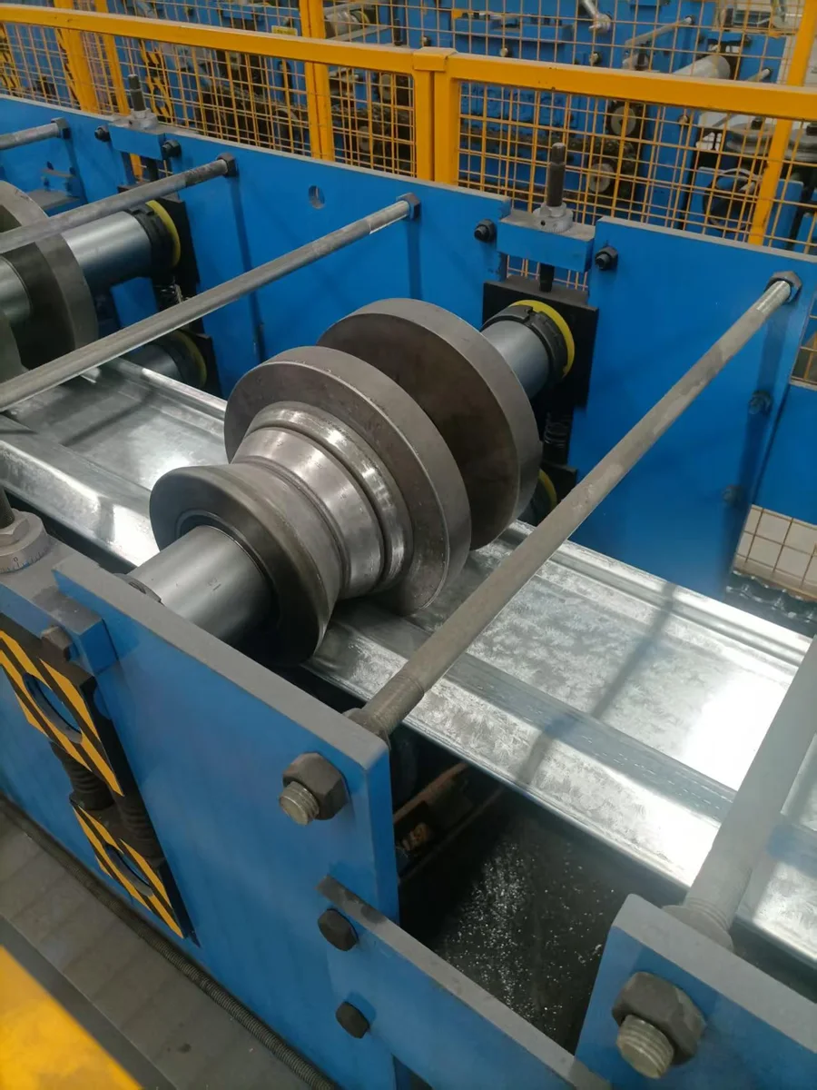 Close-up of rollers shaping a galvanized steel section